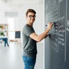 Guy writing on a chalkboard
